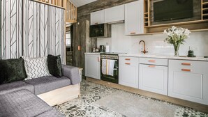 A modern kitchen with white cabinets, a built-in oven, and a large window above the sink. - Hillside Lodge - UKC8191 (Rhayader and the Elan Valley)