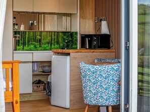 A compact kitchen with a refrigerator, microwave, and wooden cabinets. - The Foxes Den - UKC8196 (Rhayader and the Elan Valley)