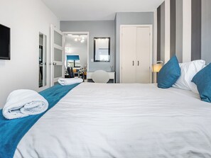 Een hotelkamer met een bed, een bureau, een stoel en een kledingkast.