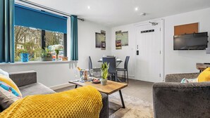 A modern living room with a sofa, a coffee table, and a dining area. - 2 bedroom accommodation in Jesmond (Jesmond)