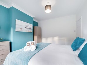 A bedroom with a bed, a wardrobe, a radiator, and a painting on the wall. - 3 bedroom accommodation in Jesmond (Jesmond)