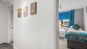 A bedroom with a bed, a window with blue curtains, and three wall-mounted artworks. - 2 bedroom accommodation in Tyne and Wear (Tyne and Wear)