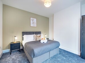 A neatly arranged bedroom with a bed, bedside tables, and a framed picture on the wall. - 3 bedroom accommodation in Newcastle Upon Tyne (Newcastle Upon Tyne)