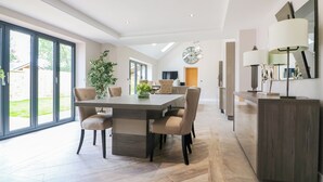 A modern dining area with a large table, chairs, and a potted plant. - 15 Chivits - UKC8971 (Warkworth)