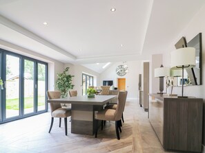 A modern dining area with a large table, chairs, and a potted plant. - 15 Chivits - UKC8971 (Warkworth)
