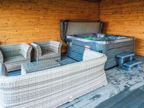 Ein Zimmer mit Holzboden, einer Badewanne und Korbmöbeln.