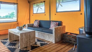 Een gezellige kamer met een bank, een kleintje tafel en een houtkachel.