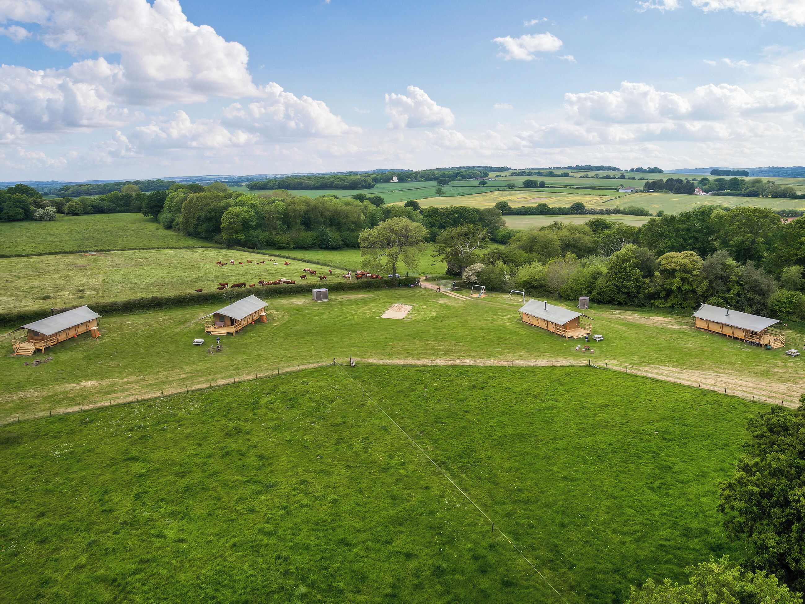 A rural farm with multiple barns and open fields.