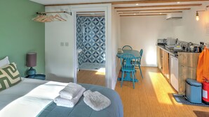 Ein Schlafzimmer mit Bett, Nachttisch, Lampe und Fenster.
