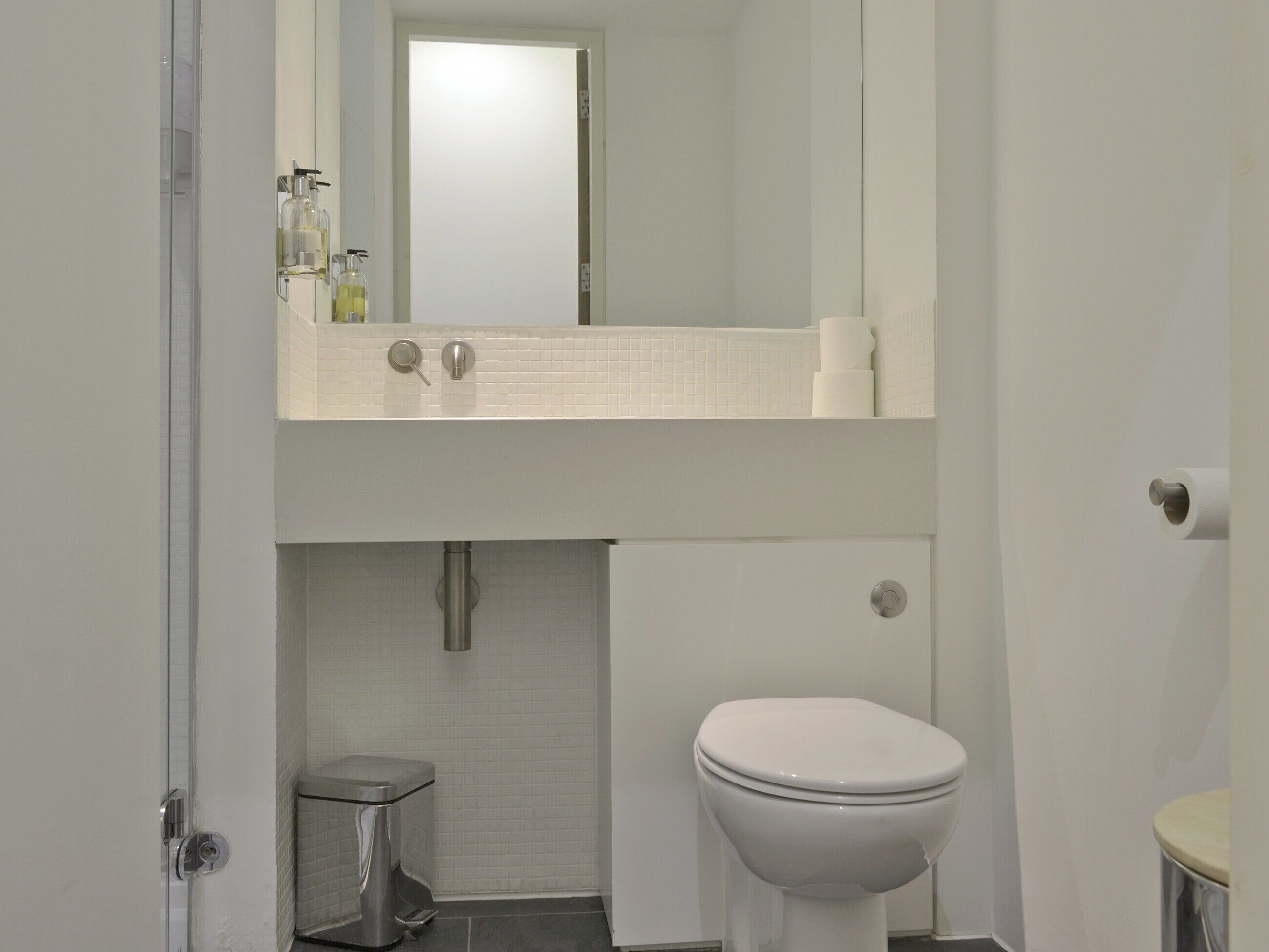 Ein Badezimmer mit Toilette, Waschbecken und Spiegel.