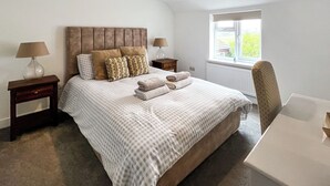 A neatly arranged bedroom with a bed, two bedside tables, a chair, and a window. - 3 bedroom accommodation in North Scarle (North Scarle)