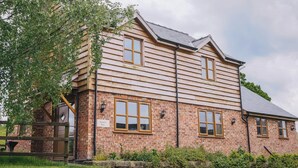 A two-story wooden building with a brick base, named 'Drover's Barn'.