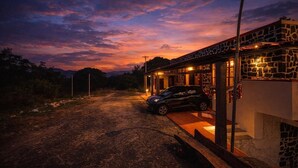 Un edificio de fachada de piedra y un coche estacionado adelante.