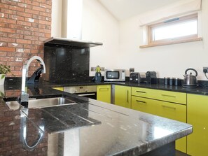 A modern kitchen with a sink, a microwave, a toaster, and a kettle on the counter. - 1 bedroom accommodation in Marhamchurch, near Bude (Marhamchurch, near Bude)