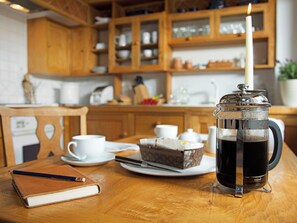 A wooden table with a coffee press, a candle, a notebook, and a teapot. - Beechnut Cottage - UKC4653 (Swerford, near Chipping Norton)