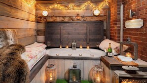 Une salle de bain rustique avec un mur en bois, une grande baignoire et une pancarte indiquant « THE COWSHED ».