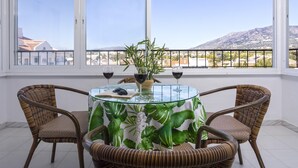 A balcony with a table, chairs, and a view of a mountain. - Sunstay Adriana Flat II Fuengirola (Fuengirola)