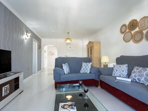 A modern living room with a sofa set, a coffee table, a TV, and decorative wall art. - Sunstay Adriana Flat II Fuengirola (Fuengirola)