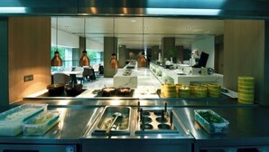 A modern kitchen with stainless steel appliances, a buffet setup, and hanging pendant lights. - JingdezhenGrand Skylight Yue Hotel (Guyao Folk Custom Expo Area) (Jingdezhen)