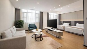 A modern hotel room with a sofa, a TV, a bed, and a small table. - JingdezhenGrand Skylight Yue Hotel (Guyao Folk Custom Expo Area) (Jingdezhen)
