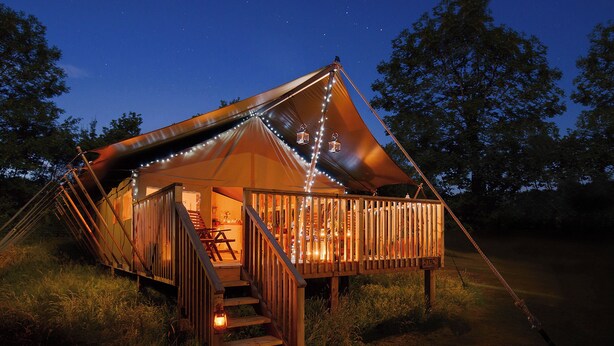 A tented accommodation with a staircase leading to a deck, surrounded by trees. - 5 Lower Keats Glamping - UKC4742 (Tytherleigh, near Axminster)