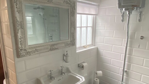 A bathroom with a white sink, mirror, and shower. - There’s a copper bath in the bedroom - Enough said. (Berwick-on-Tweed)