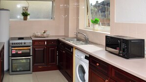 Une cuisine équipée d’un lave-linge, d’un four à micro-ondes et d’une cuisinière.