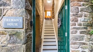 Un escalier en pierre mène à une pièce sur laquelle est apposée une plaque indiquant : « Maison des pompiers ».