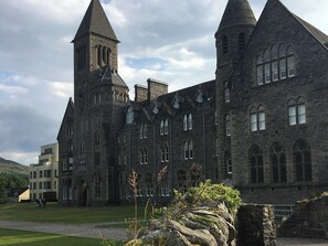 Un edificio de piedra grande con múltiples torres y ventanas arqueadas, presumiblemente histórico o institucional.