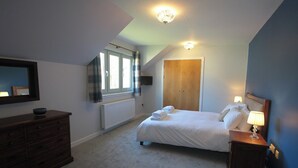 A bedroom with a bed, bedside table, dresser, window, and a ceiling light fixture. - Cottage 7 - Skye Cottage - ukc4884 (Fort Augustus)