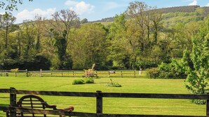 A fenced outdoor area with a bench, trees, and a grassy field. - 2 bedroom accommodation in Timberscombe, near Minehead (Timberscombe, near Minehead)