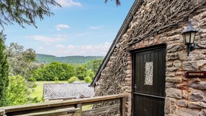 A stone building with a wooden gate, a black door, and a sign that reads 'HORNER'. - 1 bedroom accommodation in Timberscombe, near Minehead (Timberscombe, near Minehead)