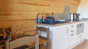 Een kleine keuken met houten wanden, een spoelbak, een koffiezetapparaat en een broodrooster.