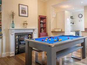 A pool table in a room with a fireplace, bookshelves, and a clock on the wall. - 3 bedroom accommodation in York (York)