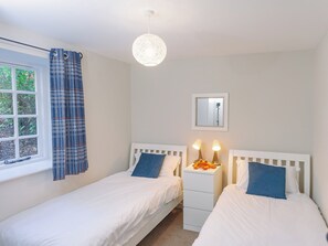 A bedroom with two single beds, a window with curtains, a bedside lamp, and a hanging light fixture. - Number One - UKC4963 (Tawstock, near Barnstaple)