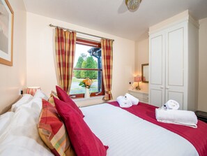 A hotel room with a large bed, a window with curtains, a bedside table with a lamp, and a wardrobe. - Munro View - UKC5040 (Aviemore)