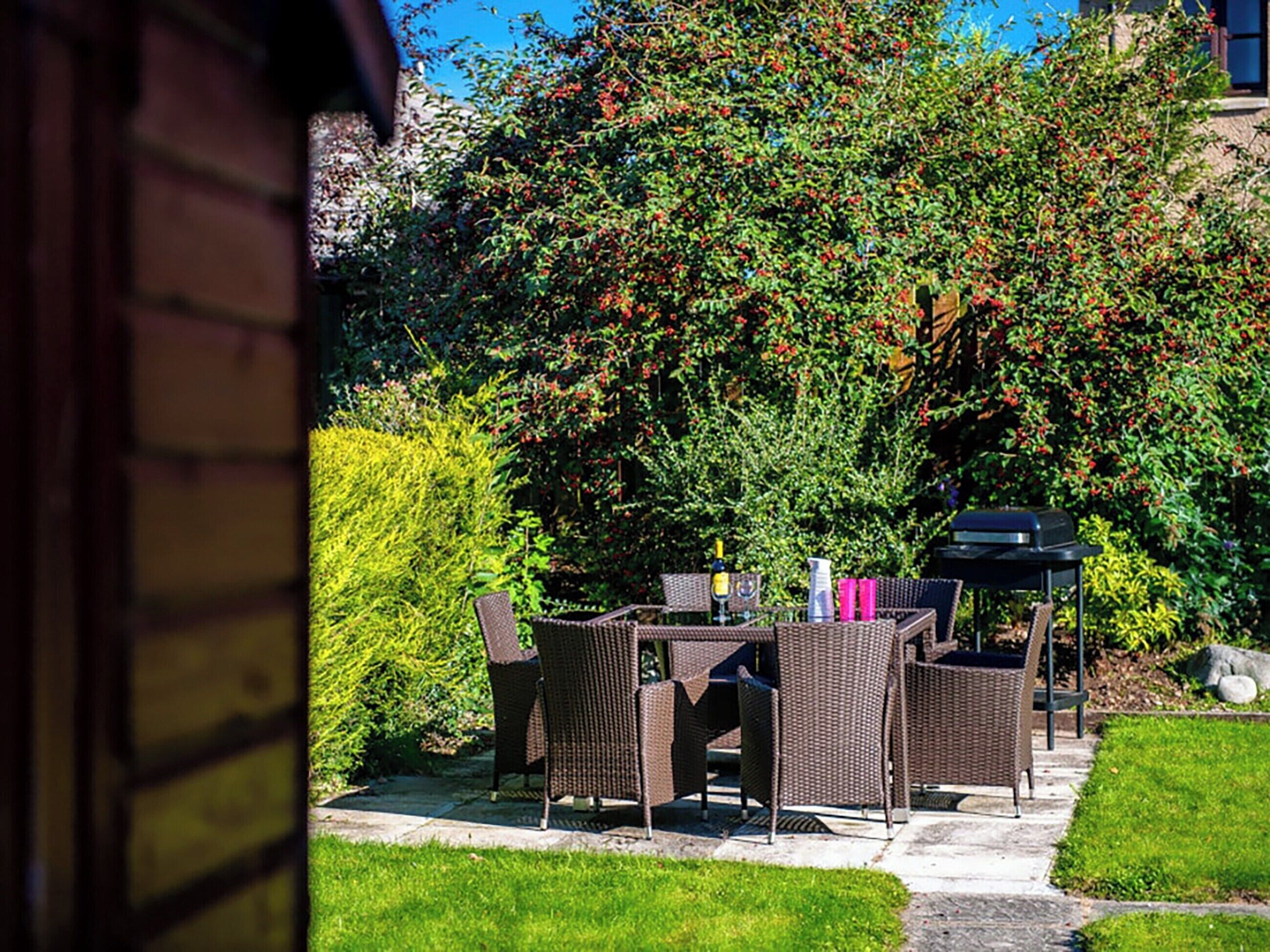 An outdoor patio with wicker furniture and a barbecue grill.