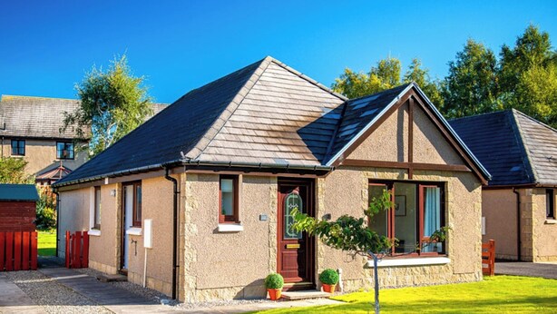 A single-story house with a pitched roof, a front porch, and a small front yard. - 3 bedroom accommodation in Aviemore (Aviemore)