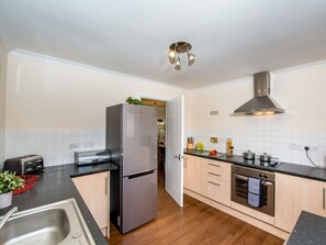 Eine moderne Küche mit einem Edelstahlkühlschrank, einem Einbauofen und einem Gasherd.