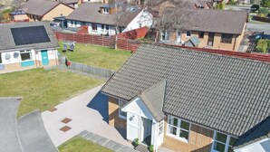 Zona residencial amb cases de teulada inclinada i façanes combinades de rajola i revestiment.