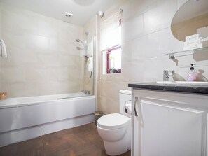 Ein modernes Badezimmer mit Badewanne, Toilette und Waschbecken.