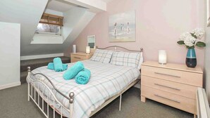 A bedroom with a bed, bedside tables, a dresser, a window, and a painting on the wall. - Larrach Beag-UKC5059 (Aviemore)