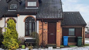 A two-story house with a tiled roof, a brick entrance, and a small porch. - Larrach Beag-UKC5059 (Aviemore)
