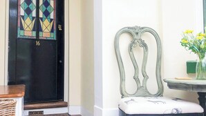Una puerta negra con un ventanal de vitral de colores y el número 16.