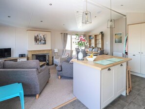 A modern living room with a fireplace, a dining area, and a kitchen island. - No 7 North - UKC5129 (Ryde)
