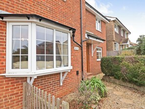 A red brick house with a white window and a wooden fence. - 4 bedroom accommodation in Ryde (Ryde)