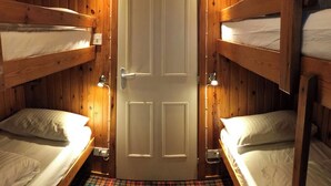 A room with wooden bunk beds, a plaid-patterned floor, and a white door. - Cedar Chalet 17 - UKC5236 (Crieff)