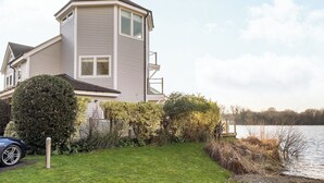 A two-story house with a sloped roof, a visible garage, and a well-maintained lawn.