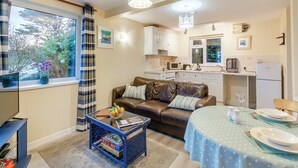 A compact living space with a sofa, coffee table, and dining table set up. - 8 Mount Brioni - UKC5343 (Torpoint)