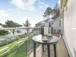 A balcony with a table, chairs, and a view of the sea and greenery. - 11 Mount Brioni - UKC5345 (Torpoint)